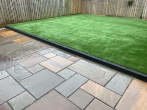 Artificial lawn with a Indian sandstone patio