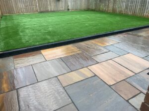 Artificial lawn with a Indian sandstone patio